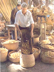 Hombre manipulando alimentos con cestos de mimbre y esparto en un mercado de Elche