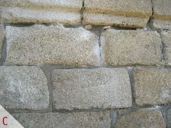 C - Eflorescencias salinas ligadas a los morteros de cemento que rejuntan la sillería granítica.
