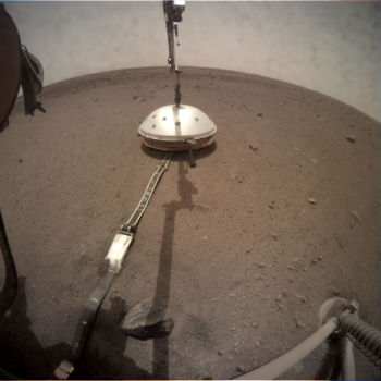  El aterrizador InSight de la NASA desplegó su escudo térmico y contra el viento el 2 de febrero (Sol 66). El escudo cubre el sismómetro de InSight, que se colocó en la superficie marciana el 19 de diciembre.  Esta imagen fue tomada por la Cámara de Implementación de Instrumentos en el brazo robótico del módulo de aterrizaje. / NASA/JPL-Caltech