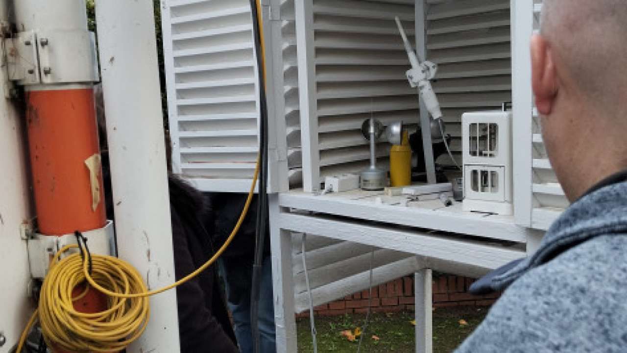 En la imagen aparece una garita meteorológica abierta en cuyo interior se aprecian instrumentos como el  termómetros o el termohigrógrafo.