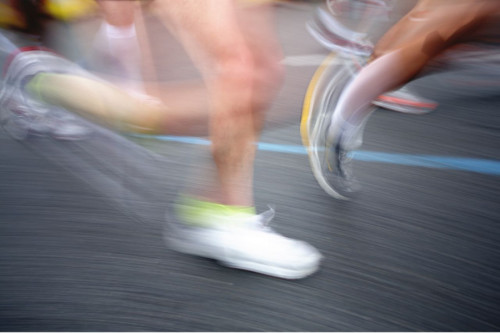 Las piernas de tres personas corriendo en una carrera