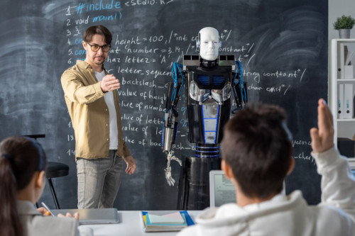Un profesor y un robot dan clase juntos a un alumno y una alumna de instituto