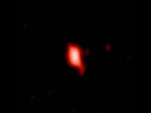 Esta imagen muestra la galaxia muy distante MACS1149-JD1, vista tal y como era hace 13.300 millones de años y observada con ALMA. / ALMA (ESO/NAOJ/NRAO), Hashimoto et al.