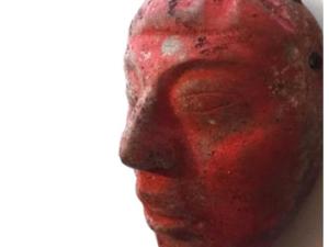 Máscara de jade de la Tumba 80, pintada de rojo- cortesía del Proyecto Arqueológico Waka y el Ministerio de Cultura y Deportes de Guatemala
