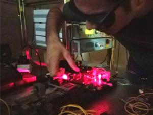 Un investigador alinea algunos componentes del láser. / CSIC