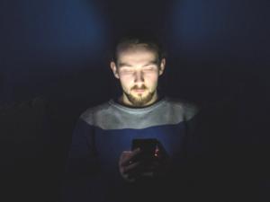 Hombre utilizando dispositivo móvil en la oscuridad. / KristopherK (PIXABAY)